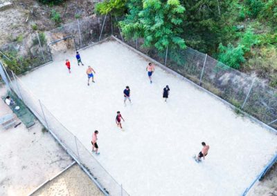 Amis jouent au foot sur le terrain de foot stabilisé du village de gîtes de Ravel