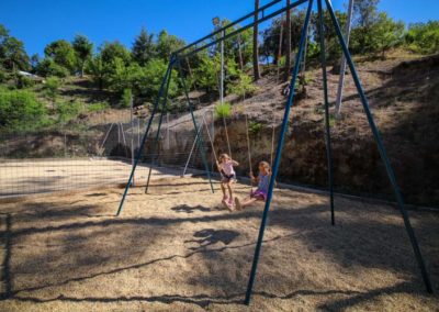 Deux petites filles se balancent sur le portique de balançoire