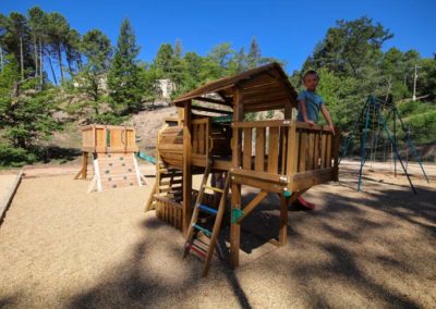 Jeune garçon debout en haut de structure en bois de l'aire de jeux en cévennes