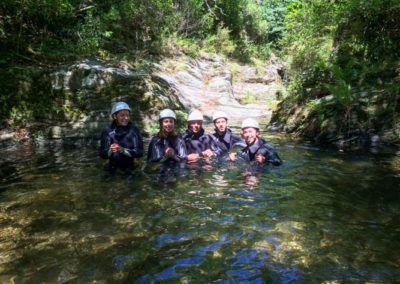 Personnes en tenue de canyoning posent pour la photo dans le canyon de schiste ombragé