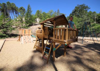 enfant debout dans un aire de jeux en bois en forme de locomotive