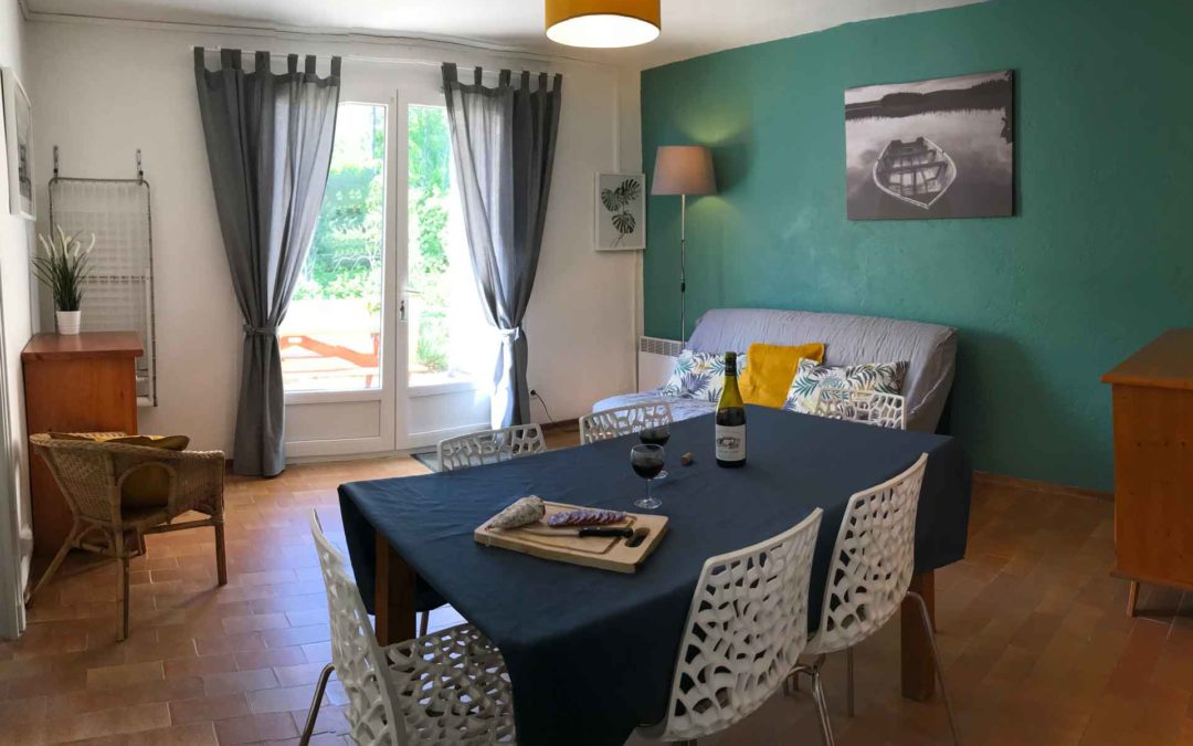 Salon salle à manger avec de jolis couleurs verte et moutarde, la double porte vitrée donne directement sur la terrasse ensoleillée