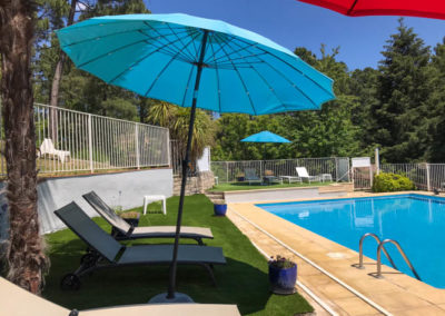 Transats et les parasols de la piscine du village de gîtes de Ravel en Cévennes