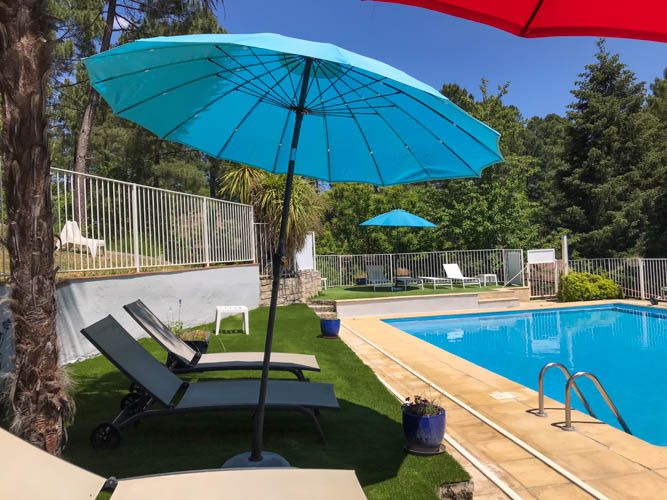 Transats et les parasols de la piscine du village de gîtes de Ravel en Cévennes