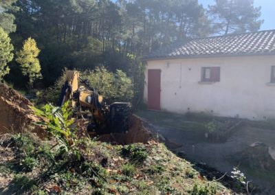 Pelle mécanique décaisse la montagne sur l'arrière du bâtiment