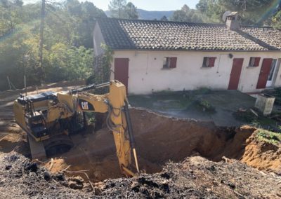 Pelle mécanique décaisse la montagne sur l'arrière du bâtiment