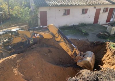 Pelle mécanique décaisse la montagne sur l'arrière du bâtiment