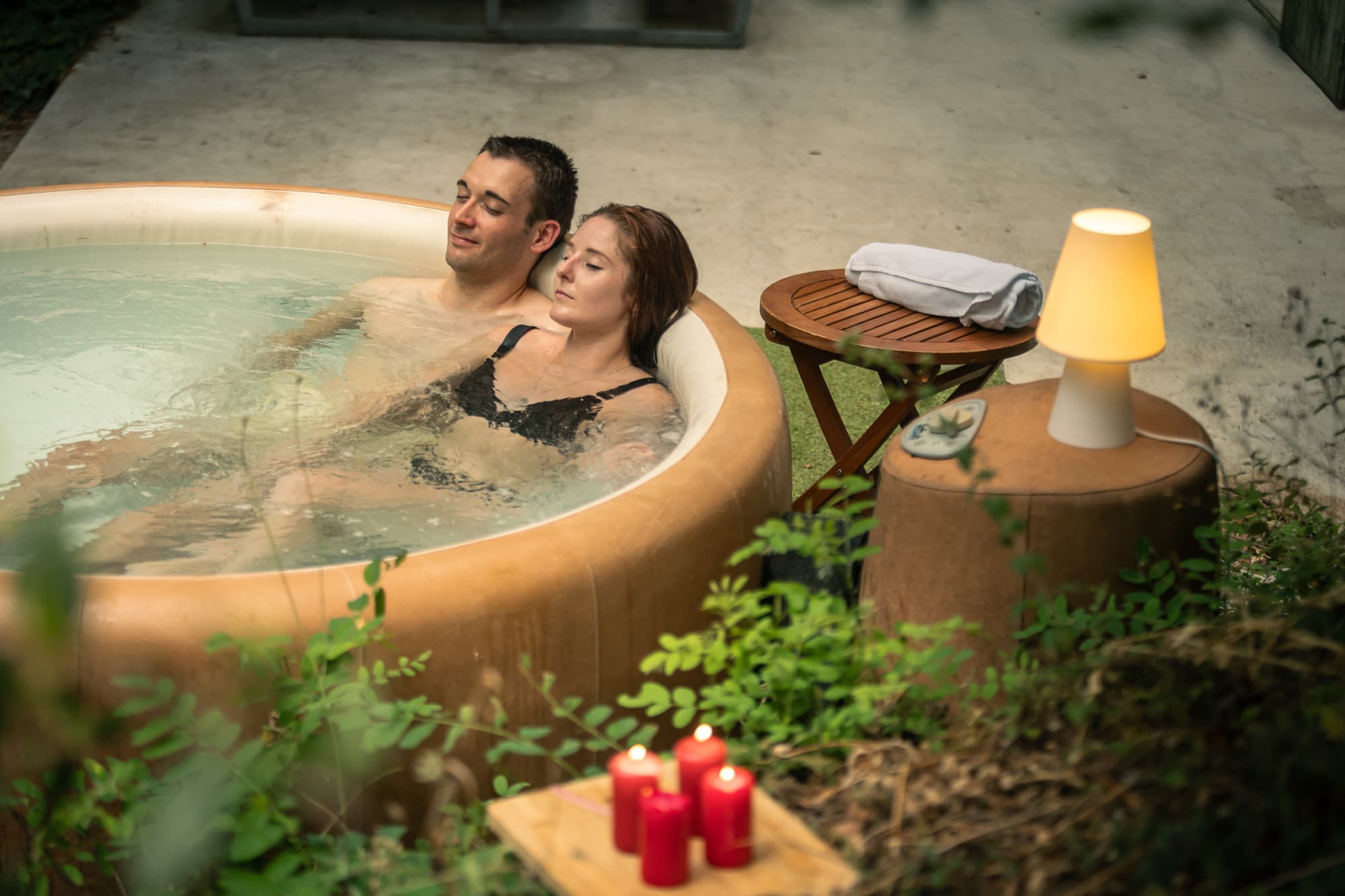 Jeune femme se prélassant dans un jacuzzi au milieu de la nature